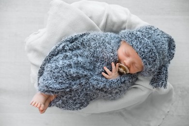 Photo of Cute newborn baby sleeping on plaid, top view
