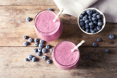 Flat lay composition with blueberry smoothie on wooden table