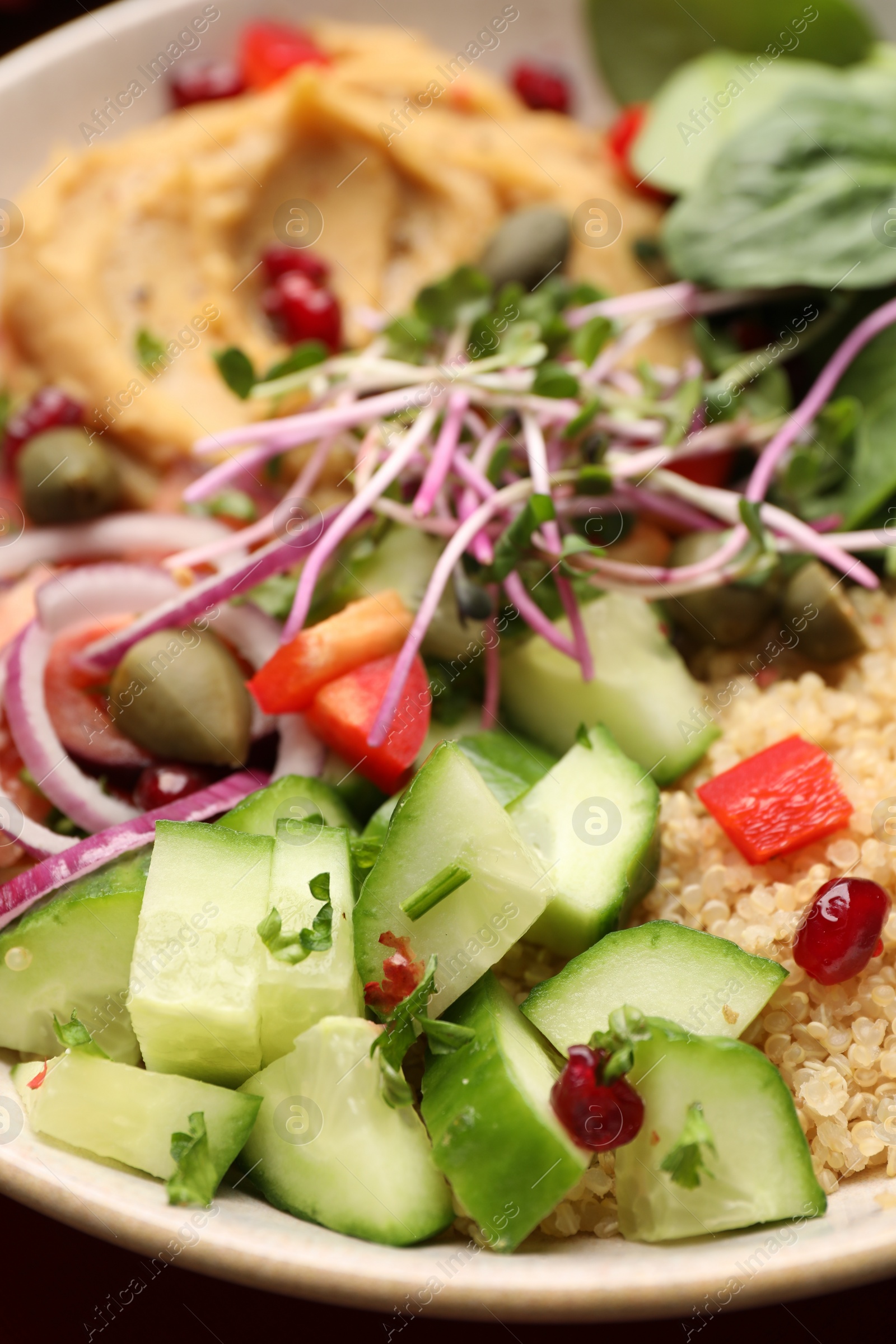 Photo of Delicious vegan bowl with cucumbers, spinach and bulgur, closeup