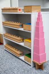 Shelving unit with different montessori toys in room