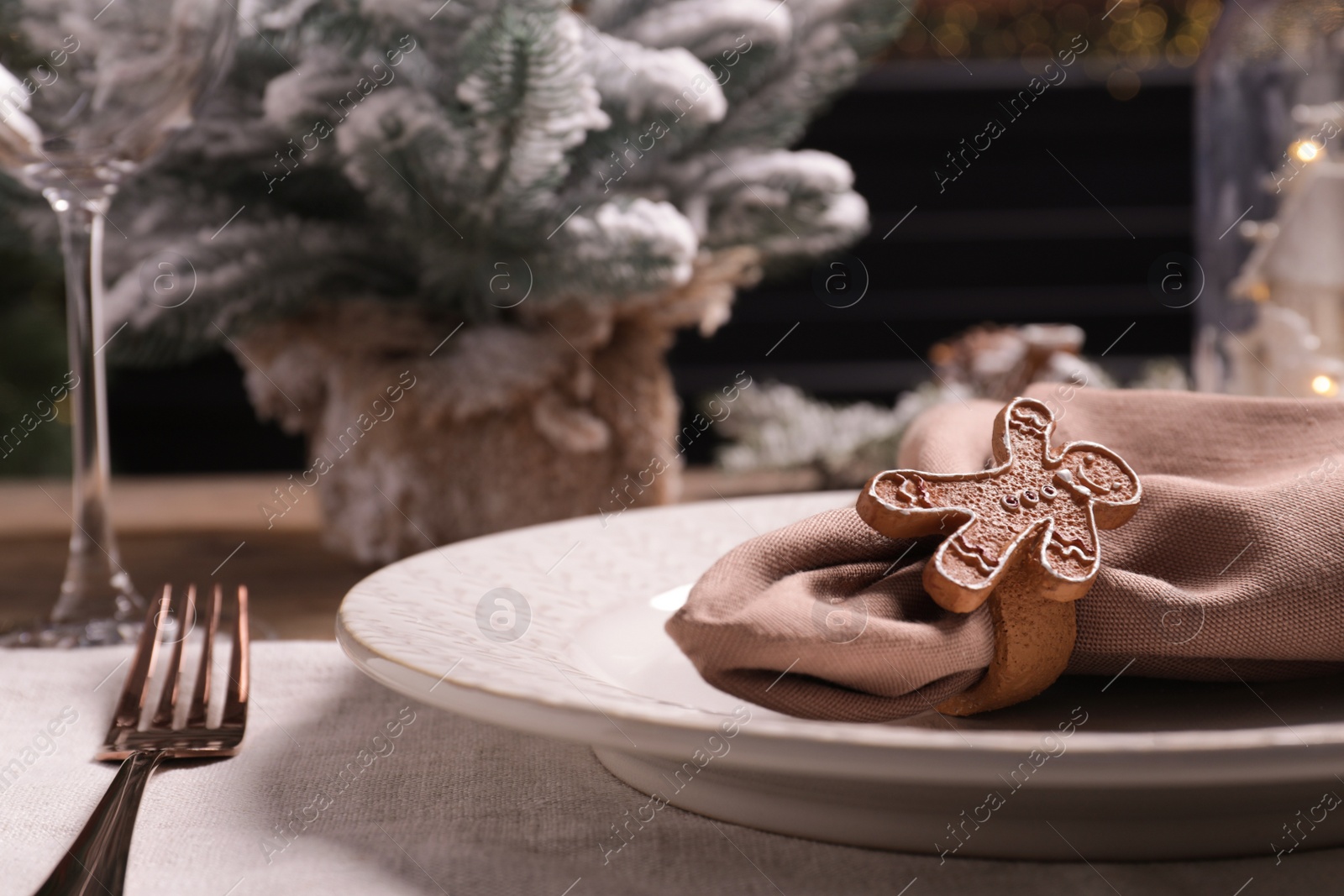 Photo of Plate, fork and fabric napkin with beautiful decorative ring on wooden table, closeup. Space for text