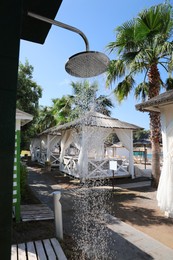 Outdoor shower with running water on beach at resort