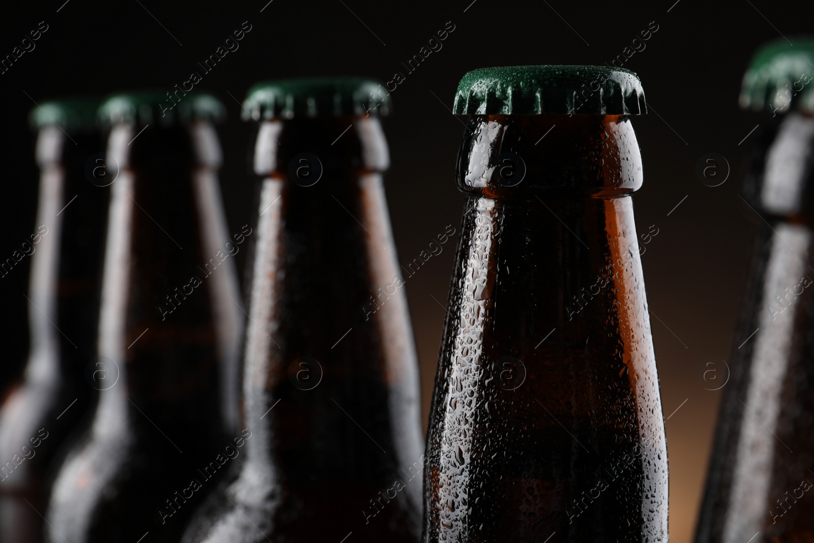 Photo of Many bottles of beer on dark background, closeup