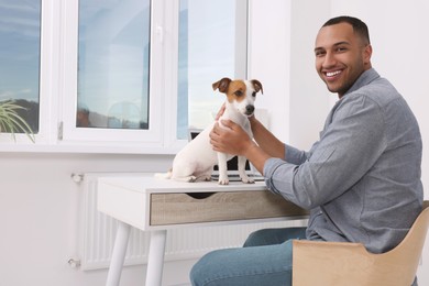 Young man with Jack Russell Terrier at desk in home office