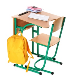 Wooden school desk with stationery and backpack on white background
