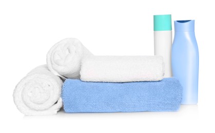 Soft terry towels with cosmetic products on white background