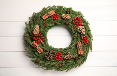 Beautiful Christmas wreath on white wooden background, top view