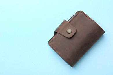 Photo of Stylish leather card holder on light blue background, top view. Space for text