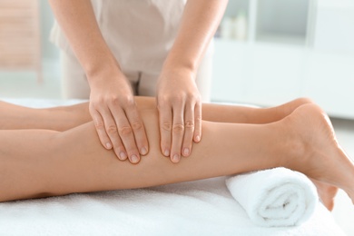 Photo of Woman receiving leg massage in wellness center, closeup