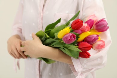 Woman holding beautiful colorful tulip flowers on white background, closeup