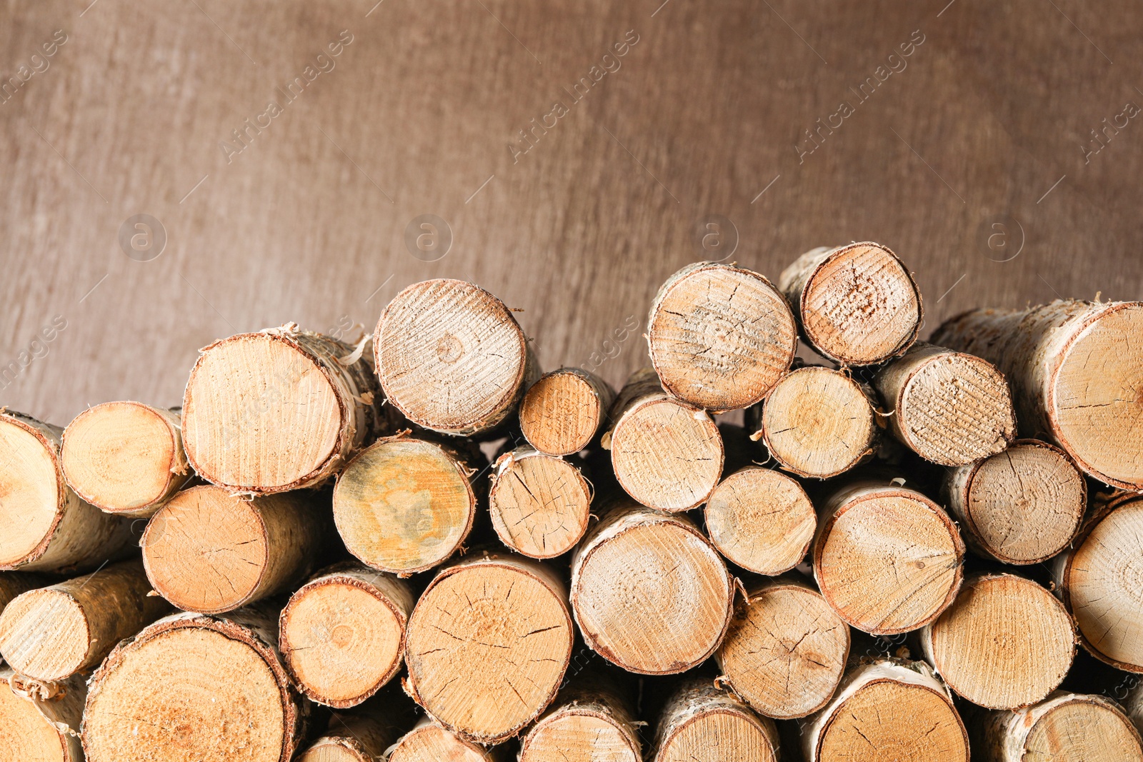 Photo of Cut firewood on brown background. Heating in winter