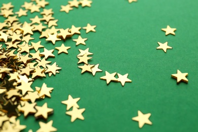 Photo of Confetti stars on green background, closeup. Christmas celebration