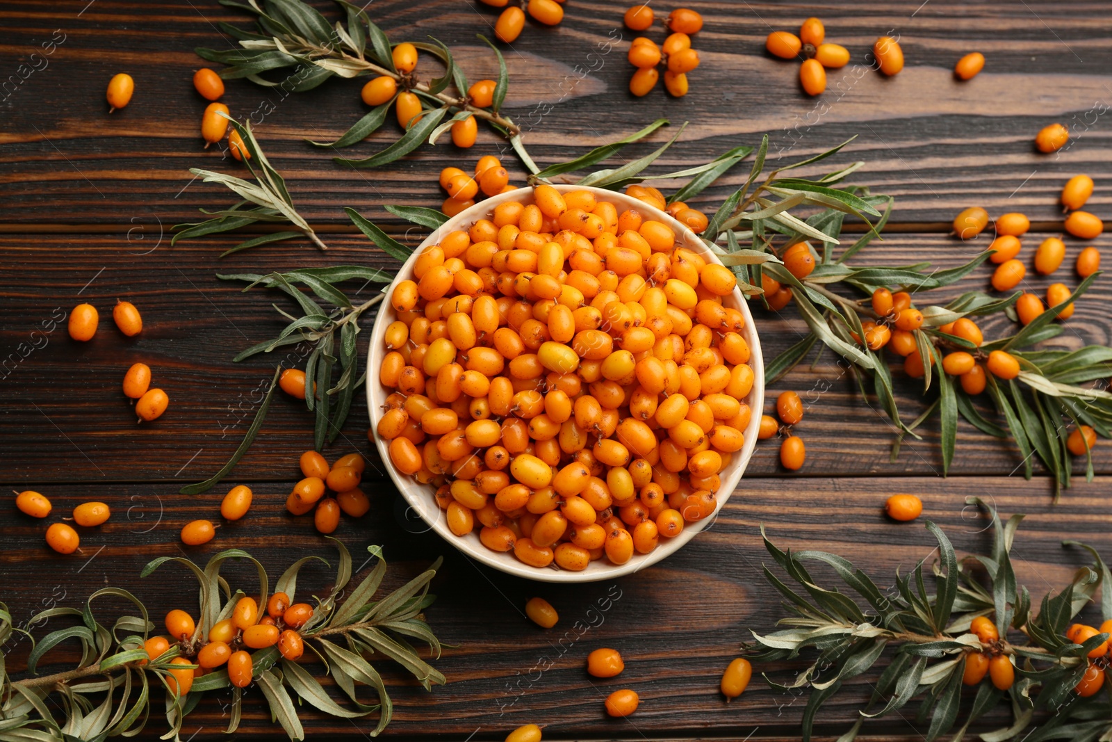 Photo of Fresh ripe sea buckthorn on wooden table, flat lay