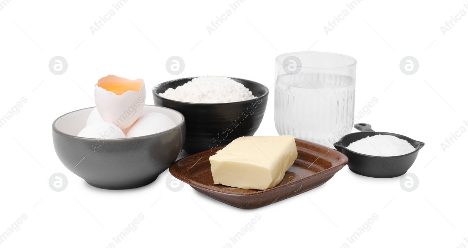 Photo of Eggs, butter, flour, salt and water isolated on white. Ingredients for puff pastry dough