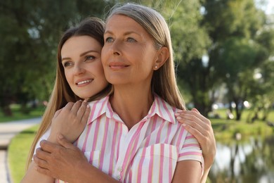 Photo of Family portrait of happy mother and daughter spending time together in park