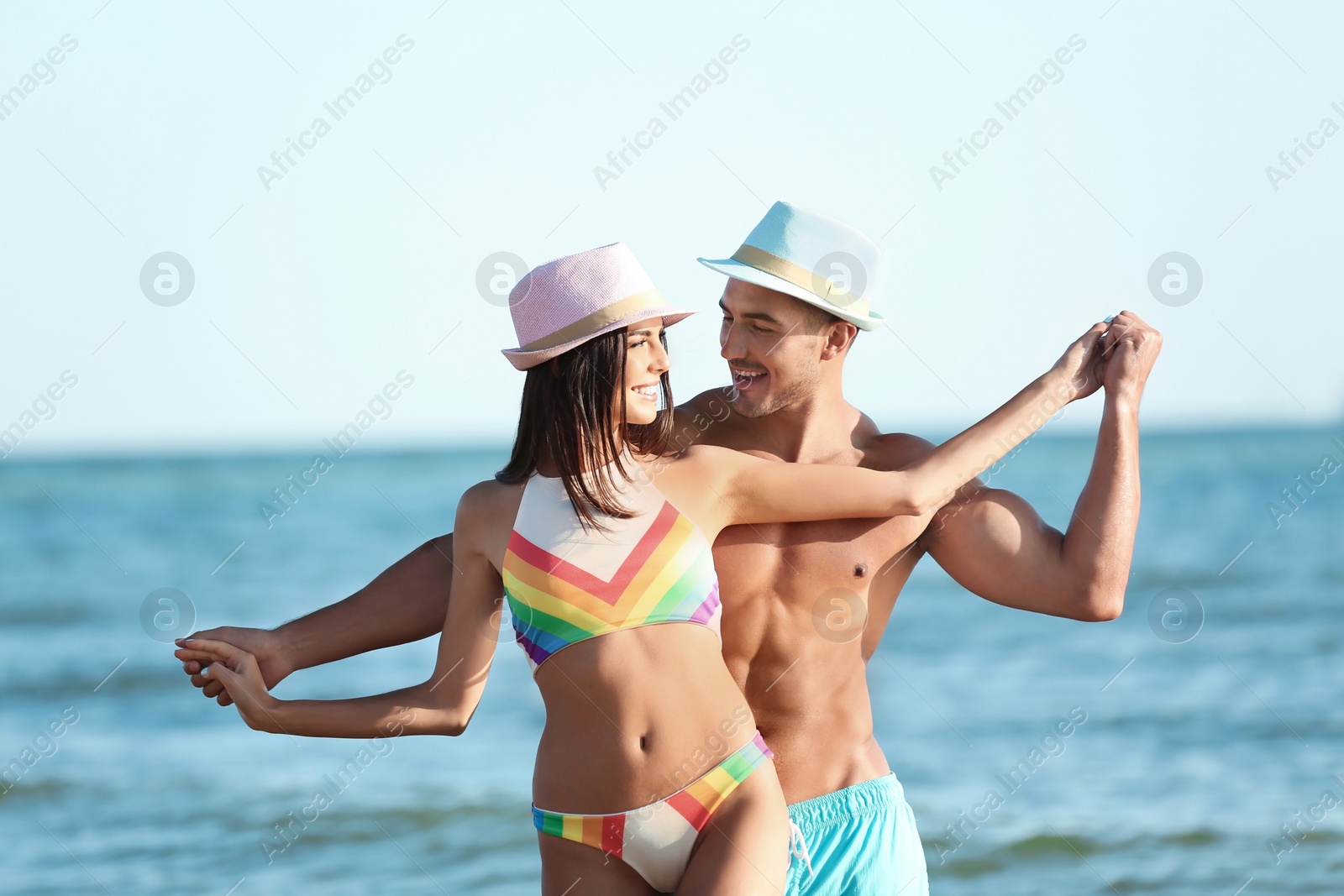 Photo of Happy young couple having fun at beach on sunny day