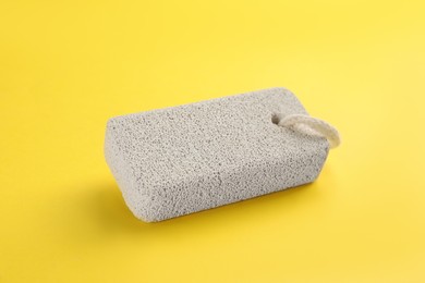 Photo of Pumice stone on yellow background. Pedicure tool