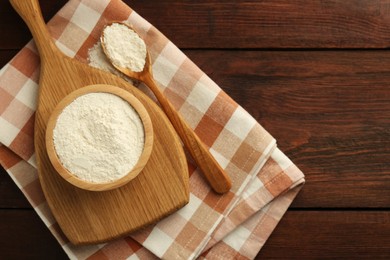 Photo of Baking powder in bowl and spoon on wooden table, top view. Space for text