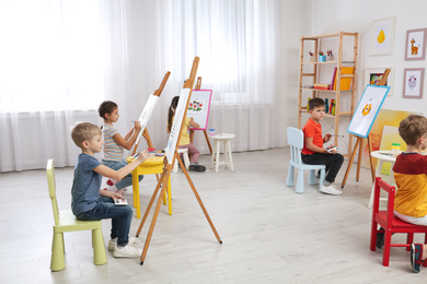Photo of Cute little children painting during lesson in room