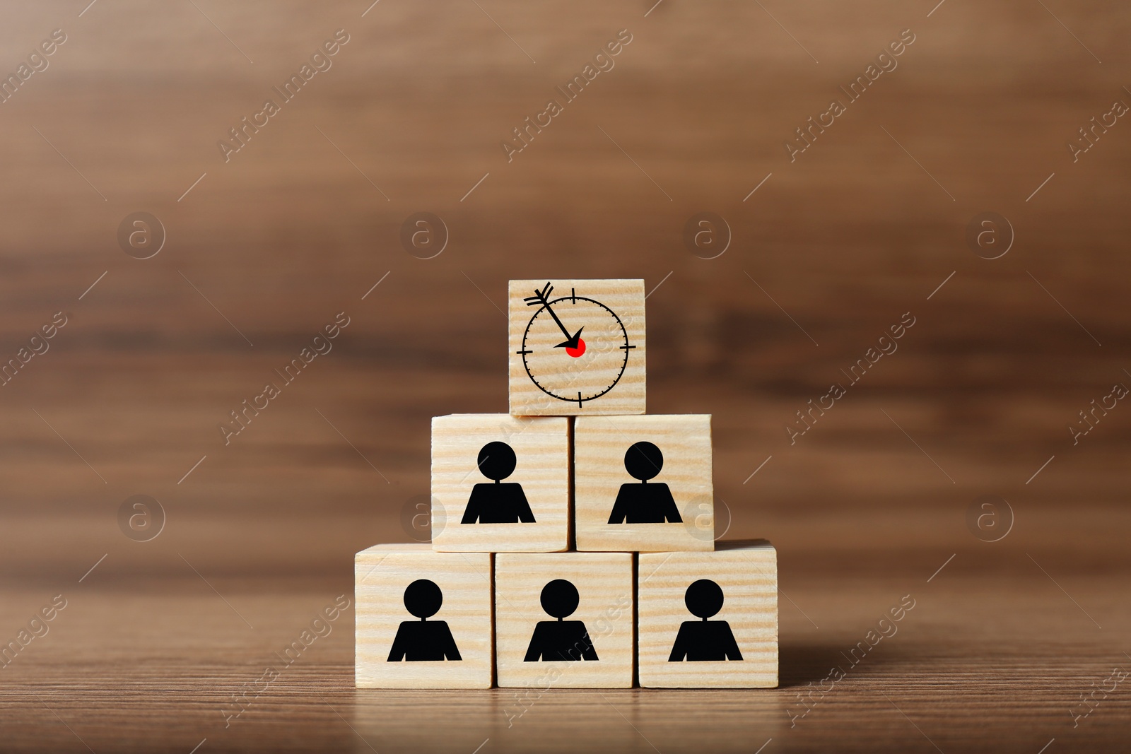 Image of Pyramid of cubes with target and human icons on wooden table