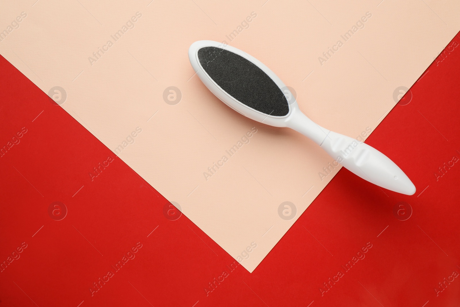 Photo of White foot file on color background, top view with space for text. Pedicure tool
