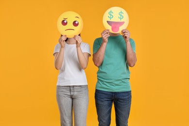 People covering faces with emoticons on yellow background