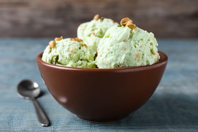 Photo of Delicious pistachio ice cream in bowl on table, closeup