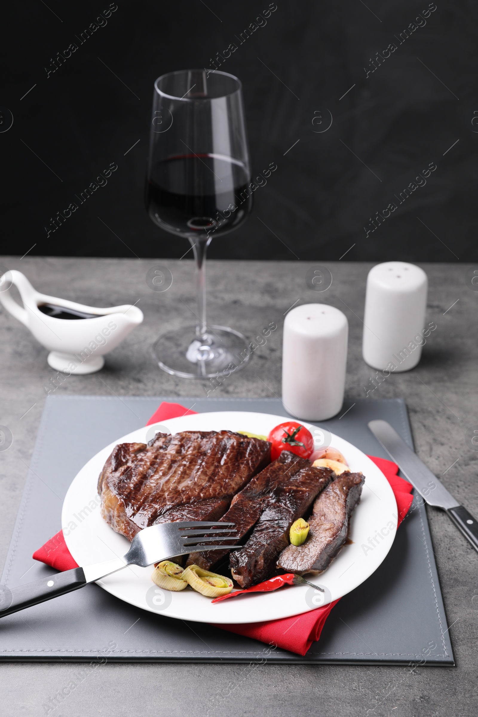 Photo of Delicious grilled beef meat served on grey table