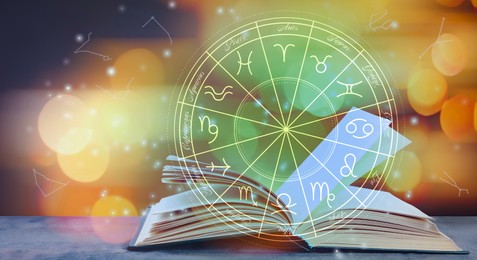 Image of Open book on wooden table and illustration of zodiac wheel with astrological signs