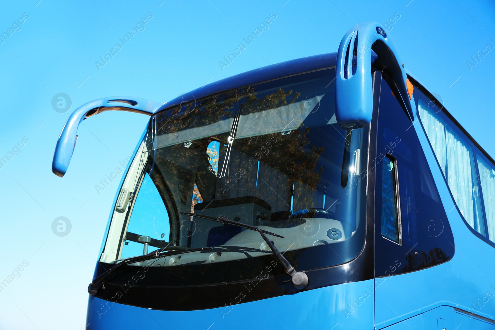 Photo of Modern blue bus against sky. Passenger transportation