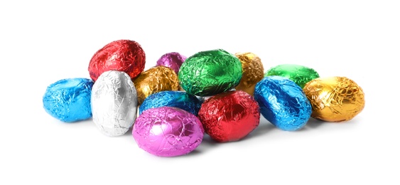 Chocolate eggs wrapped in colorful foil on white background