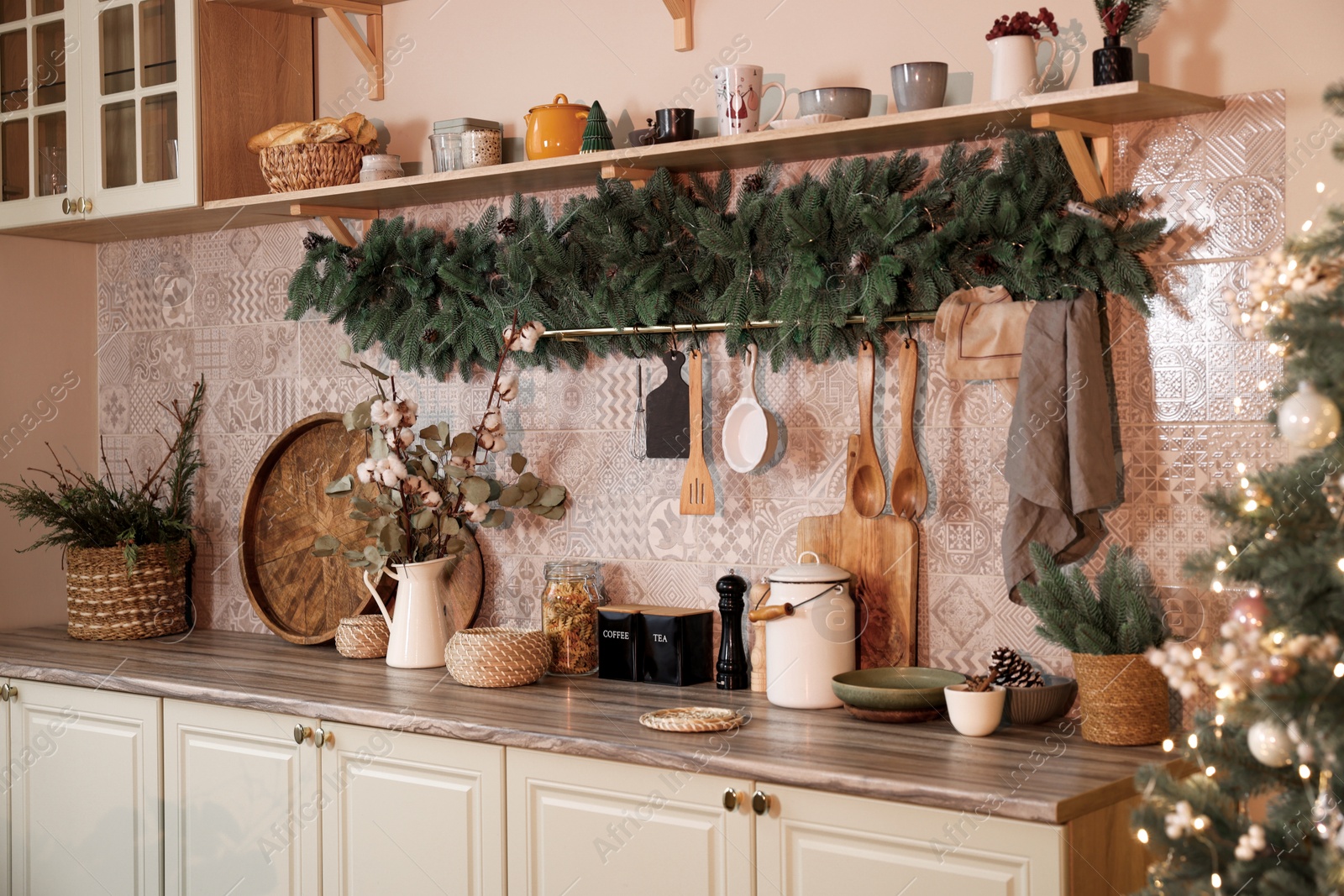 Photo of Stylish kitchen with festive decor and Christmas garland. Interior design