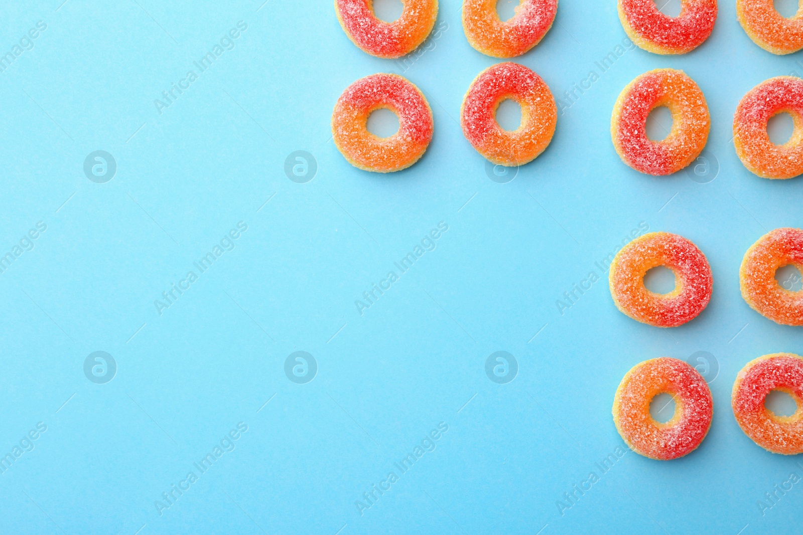 Photo of Flat lay composition with tasty jelly candies and space for text on color background