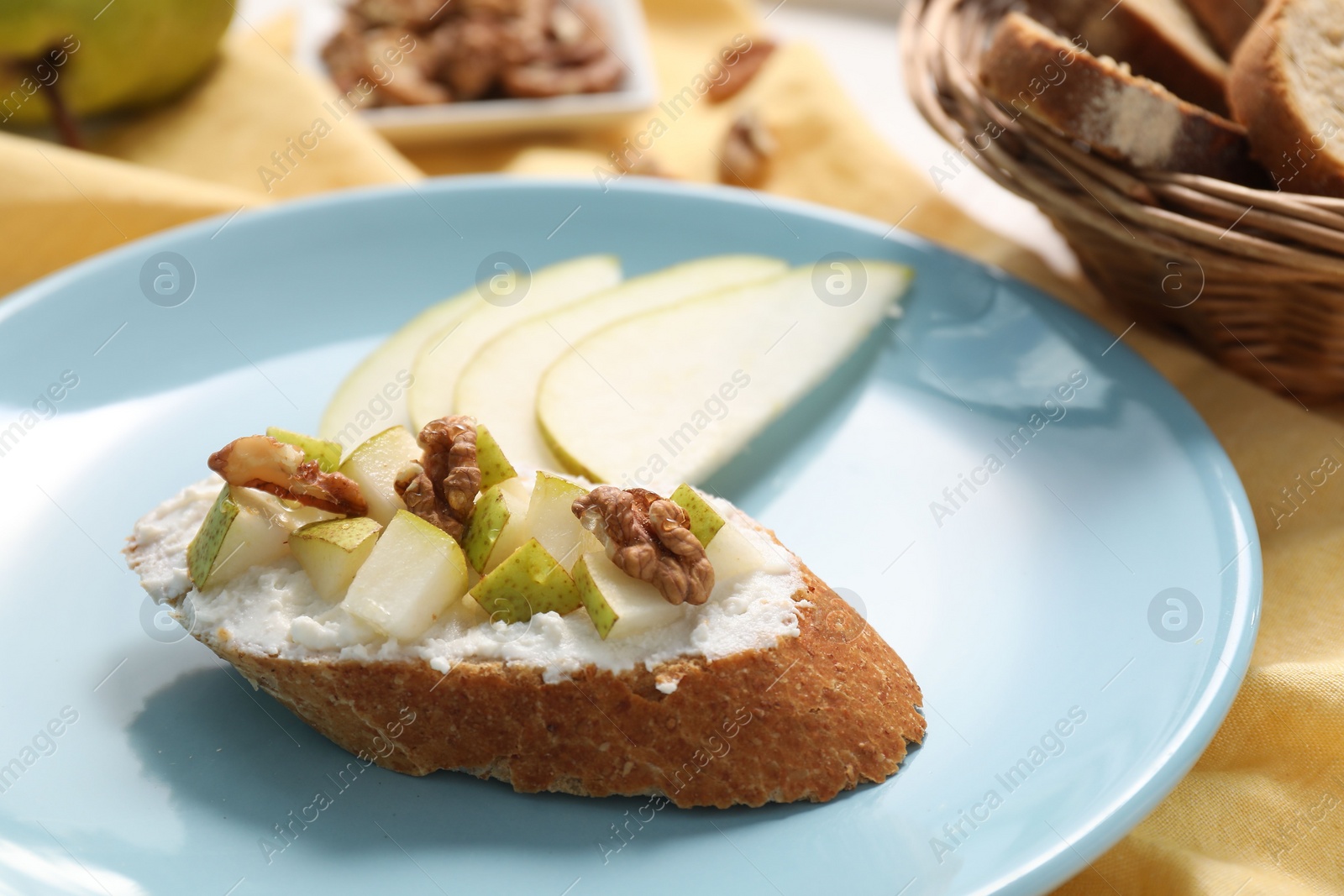 Photo of Delicious ricotta bruschetta with pear and walnut served on table, closeup
