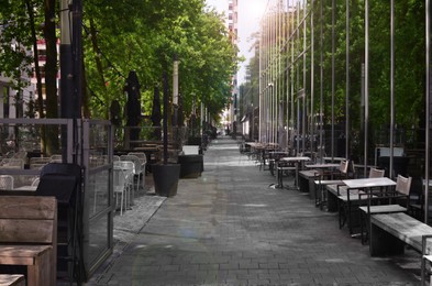 Photo of Tables and chairs on city street with modern architecture