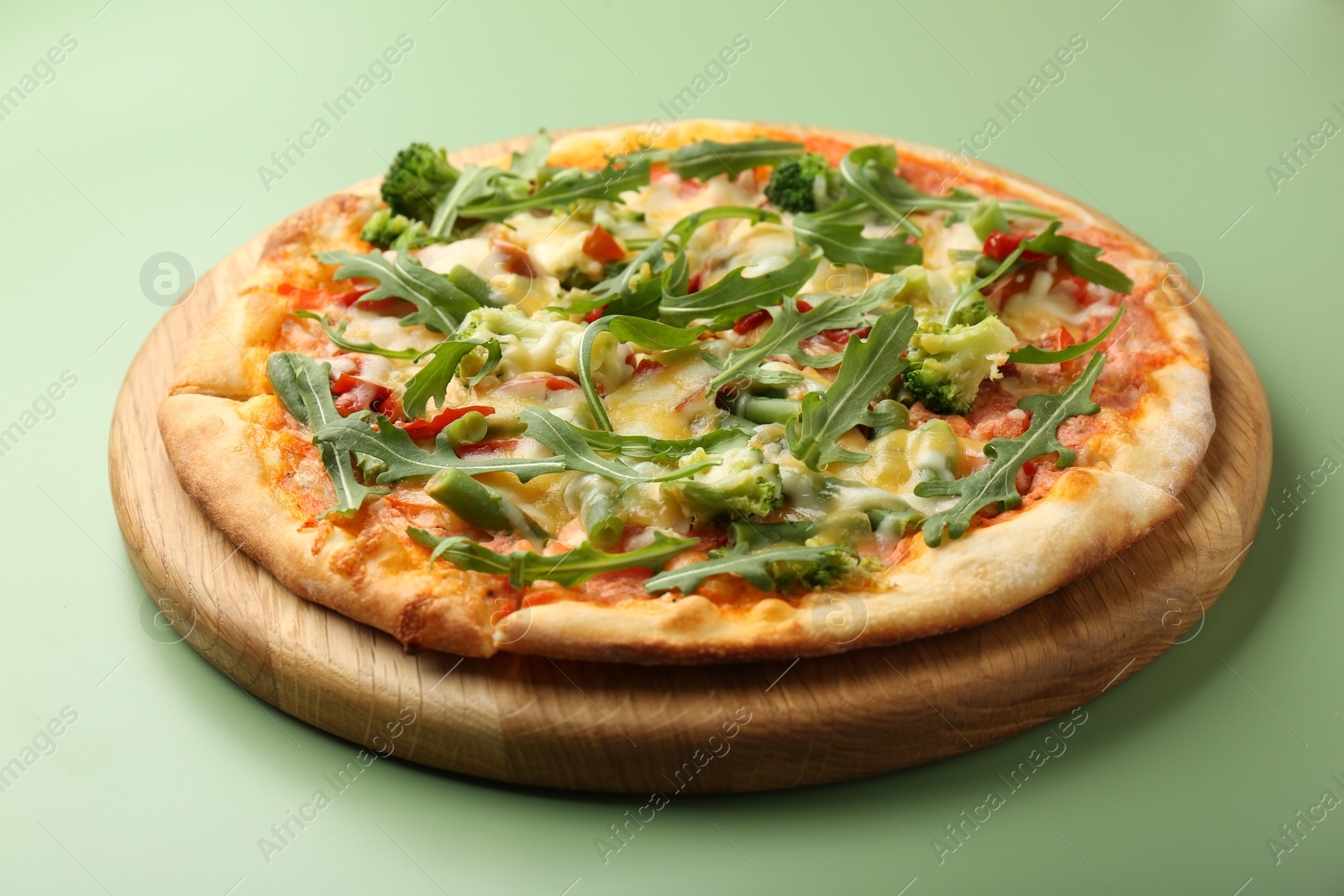 Photo of Delicious vegetarian pizza on green table, closeup