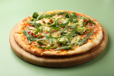 Photo of Delicious vegetarian pizza on green table, closeup