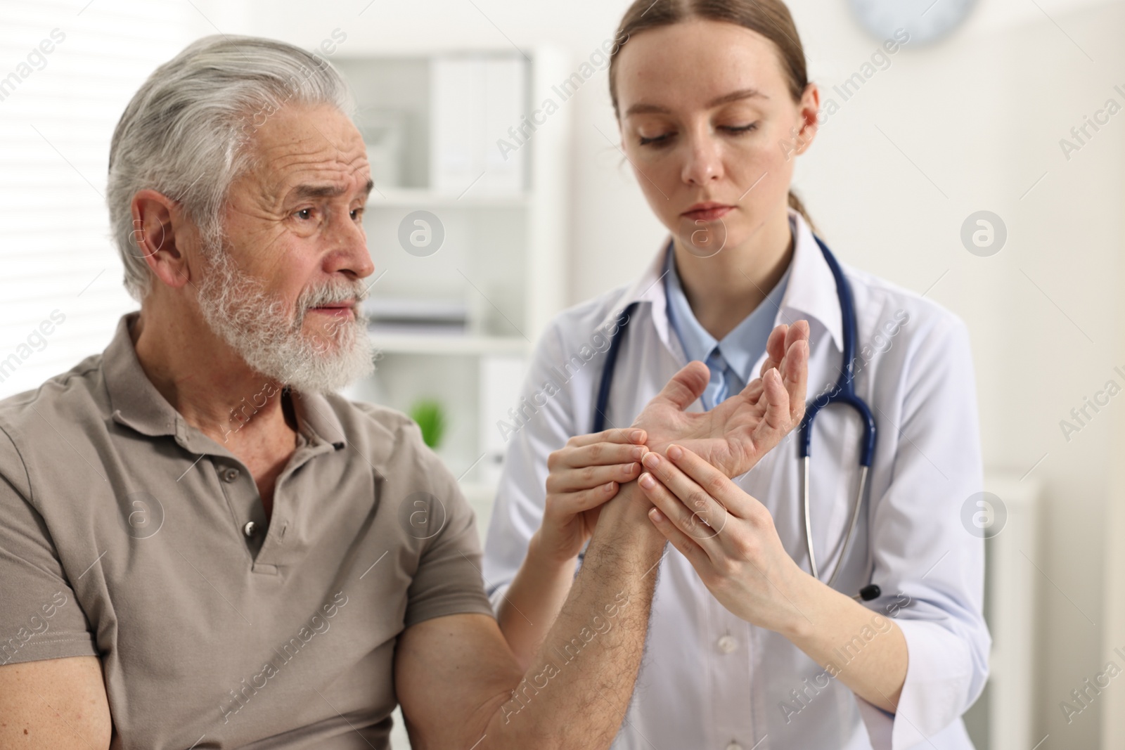 Photo of Arthritis symptoms. Doctor examining patient's hand in hospital