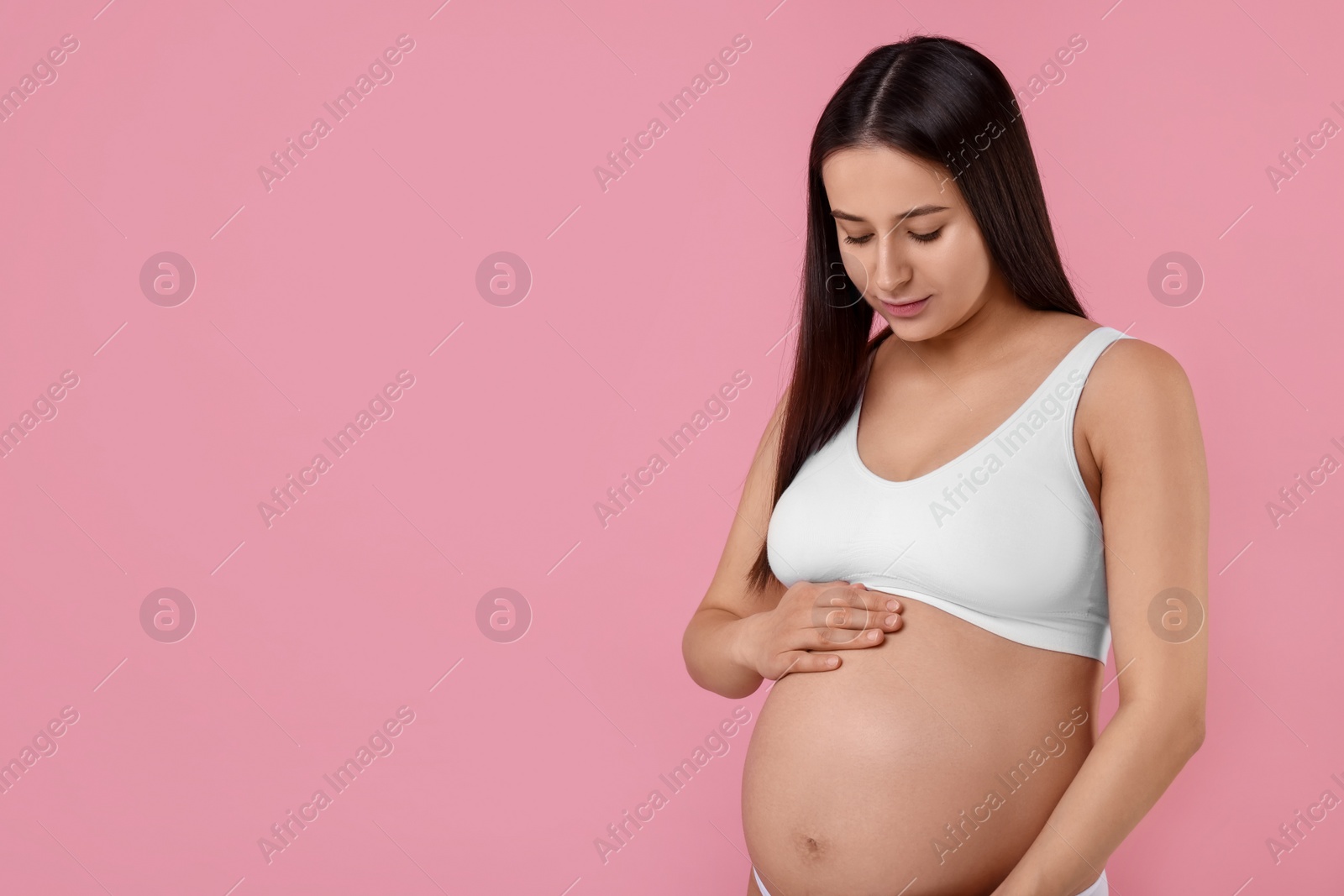 Photo of Beautiful pregnant woman in stylish comfortable underwear on pink background, space for text