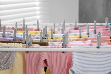 Clean laundry hanging on drying rack indoors