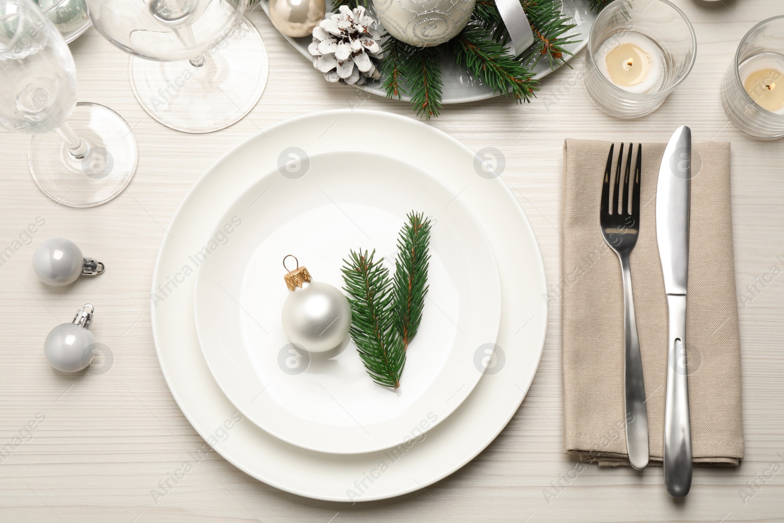 Photo of Festive table setting with beautiful dishware and Christmas decor on white wooden background, flat lay
