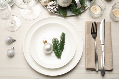 Festive table setting with beautiful dishware and Christmas decor on white wooden background, flat lay