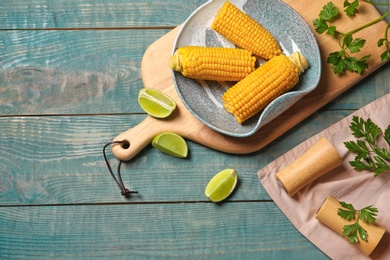 Flat lay composition with corn cobs on wooden background with space for text