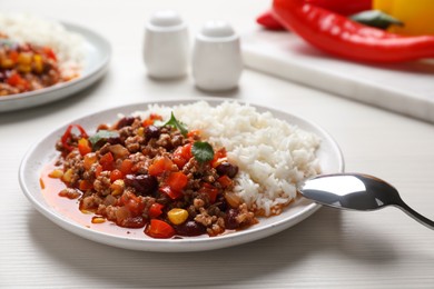 Photo of Plate of rice with chili con carne on white wooden table
