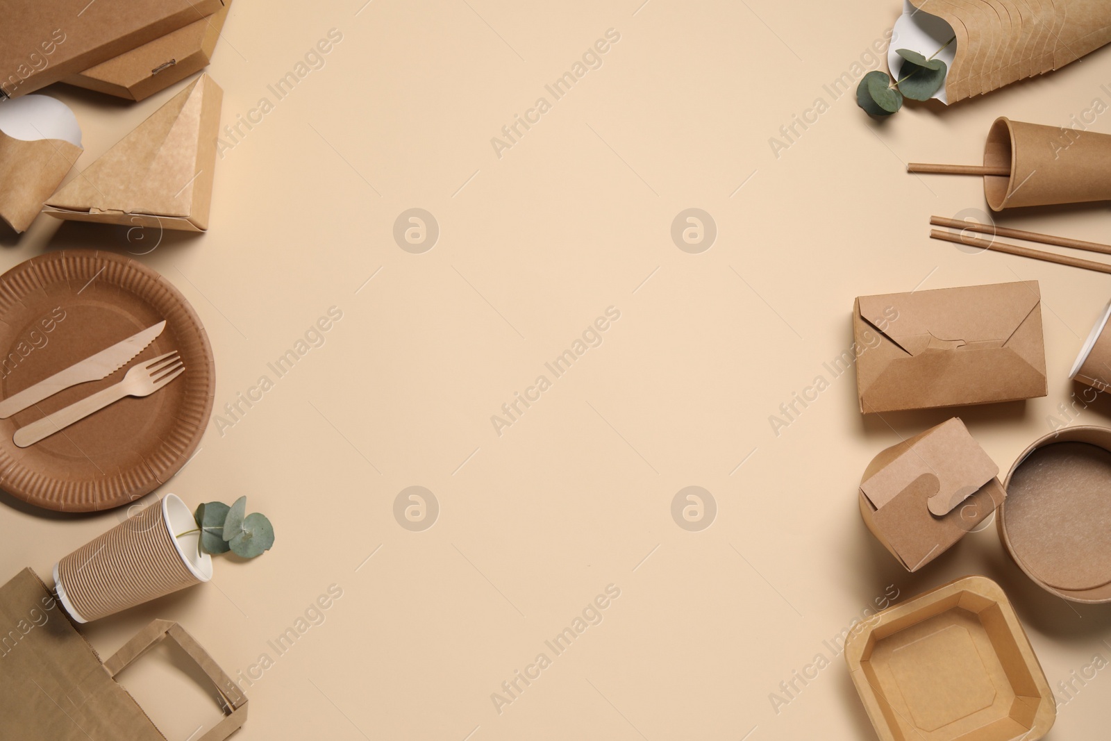 Photo of Eco friendly food packaging. Paper containers, tableware and eucalyptus leaves on beige background, flat lay. Space for text