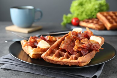 Photo of Tasty Belgian waffles served with bacon and butter on grey table, closeup