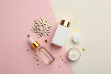 Photo of Flat lay composition with cosmetic products on pink and beige background. Winter care