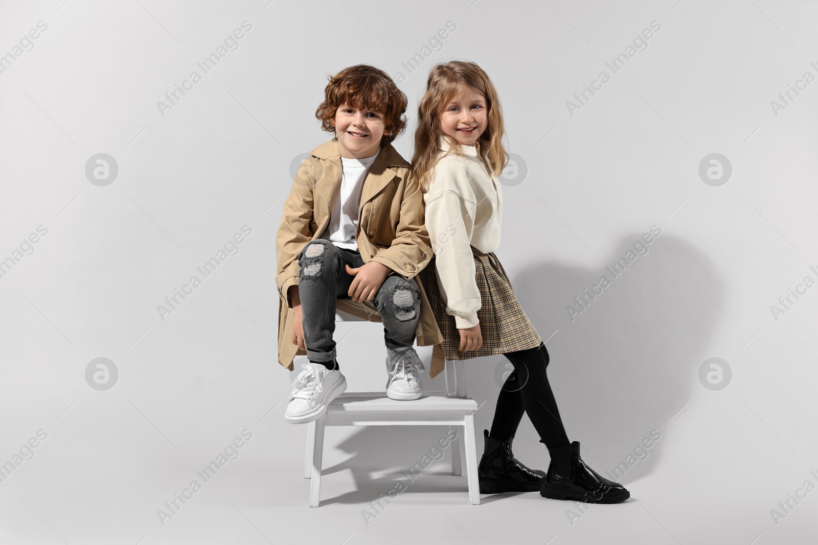 Photo of Fashion concept. Stylish children posing on light grey background