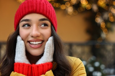 Portrait of smiling woman on city street in winter. Space for text