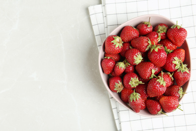 Photo of Delicious ripe strawberries in bowl on light grey marble table, flat lay. Space for text